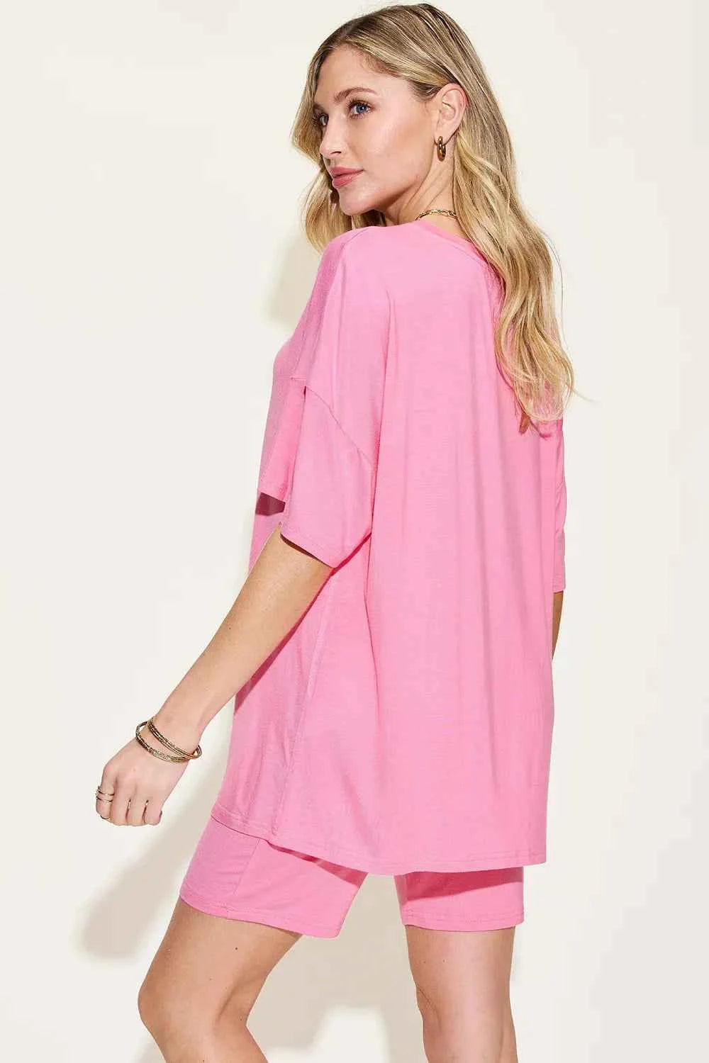 Woman in pink trendy lounge wear for women featuring an oversized top and matching shorts