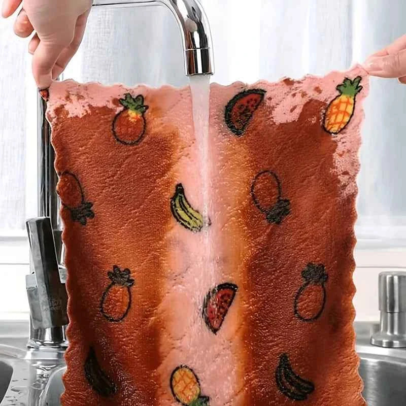 Water-absorbent dish cloth being rinsed under a faucet, featuring colorful fruit patterns