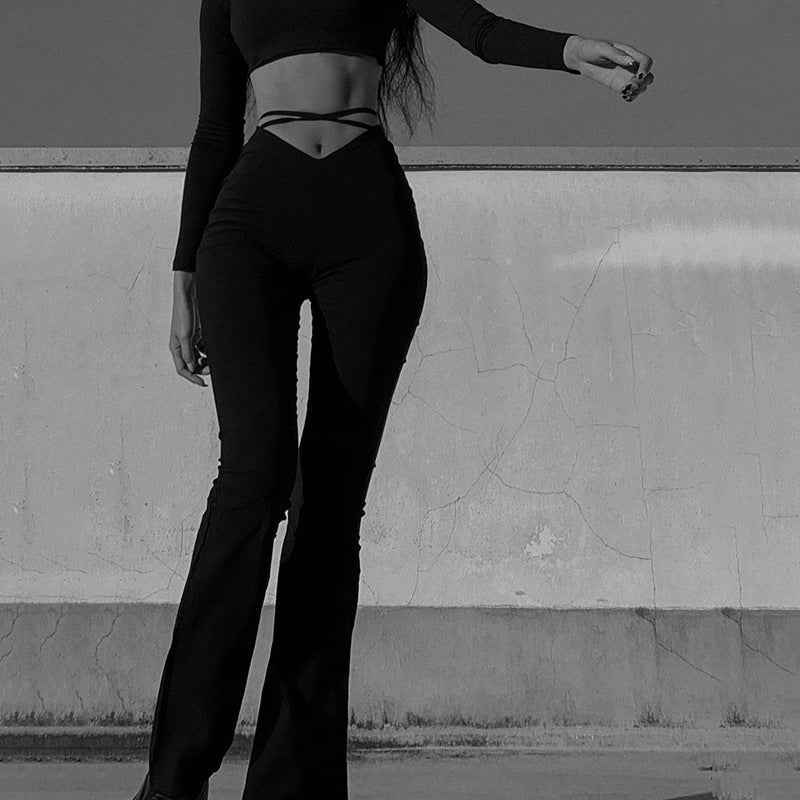 Model wearing stylish black flared track pants with high comfort paired with a matching top