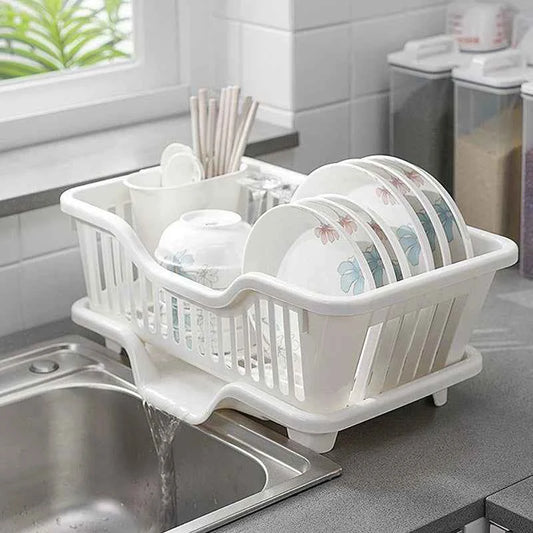 White kitchen drainage rack with plates and utensils drying next to a sink