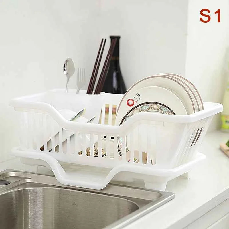 White kitchen drainage rack for drying dishes with plates and utensils beside a kitchen sink