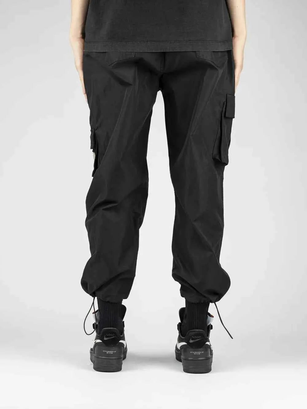 Men's drawstring cargo pants in black with side pockets and tapered ankle design