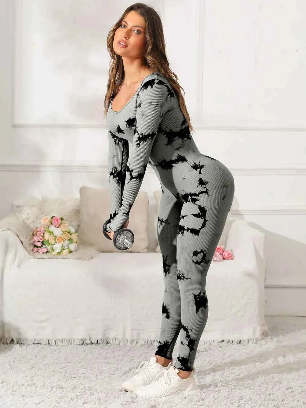 Model wearing a premium fitness jumpsuit in black and gray tie-dye pattern, perfect for workouts