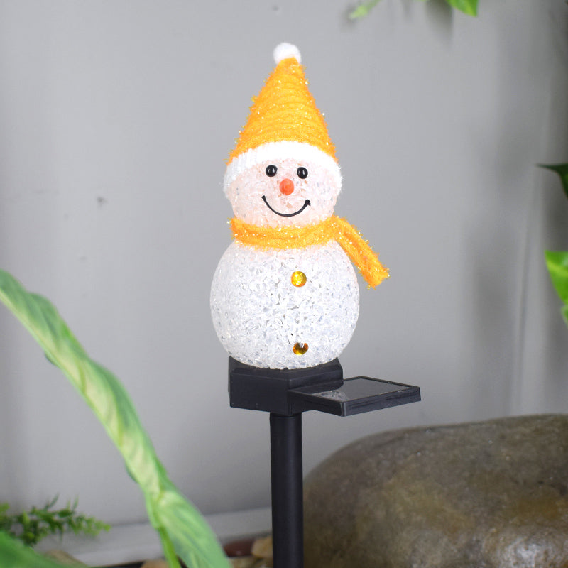 Cheerful solar snowman garden lamp with a smiling face and orange hat and scarf for outdoor decoration
