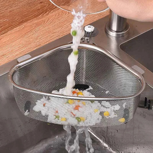 Stainless steel sink drain basket catching food particles while water drains from a sink
