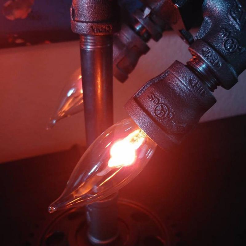 Steampunk rocket lamp decor featuring intricate metal pipe design and glowing vintage-style bulbs