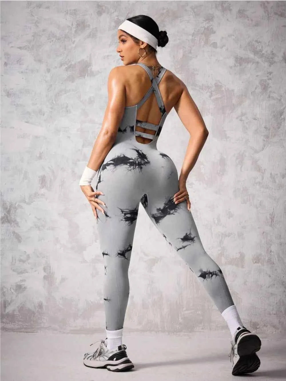 Stylish athletic jumpsuit with crisscross back detail in gray and black for an elegant workout look