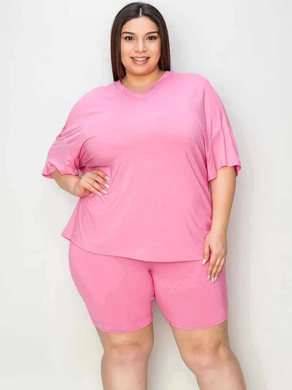 Plus-size woman in pink trendy lounge wear for women, featuring comfortable loose-fit top and shorts