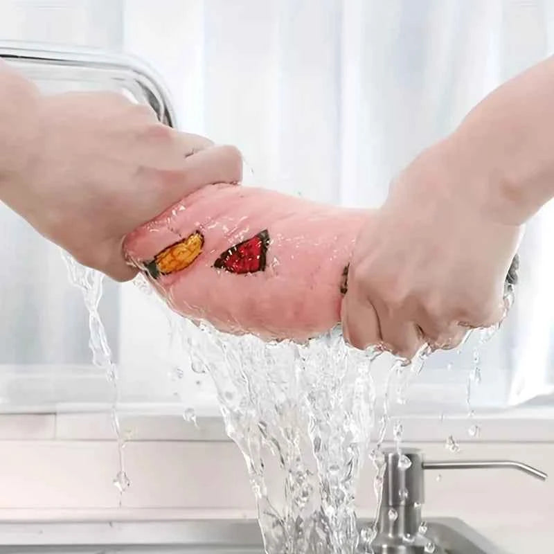 Hands wringing out a water-absorbent dish cloth under running water in a kitchen sink