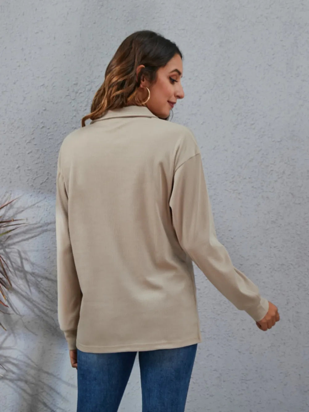 Back view of a women's classic blouse in beige, with long sleeves and a relaxed fit