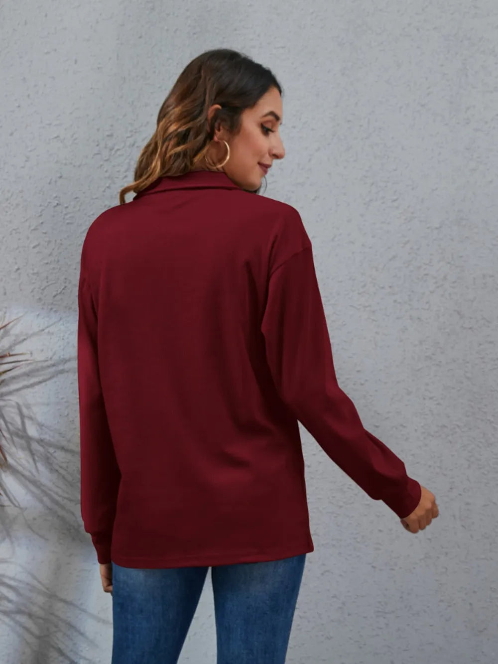 Back view of a burgundy women's classic blouse with long sleeves and a relaxed fit