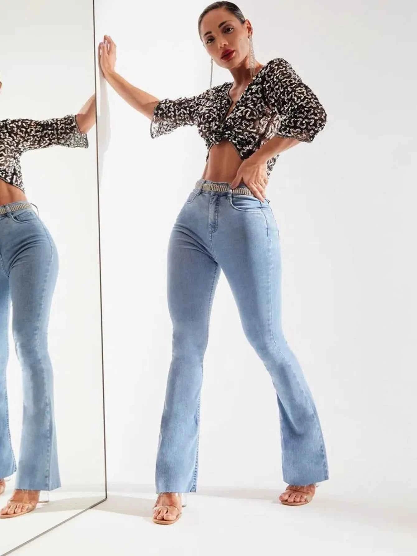Model wearing women's vintage denim pants with a flared leg and stylish top for a trendy look